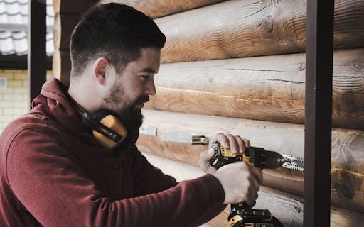 A man drills into a wall.